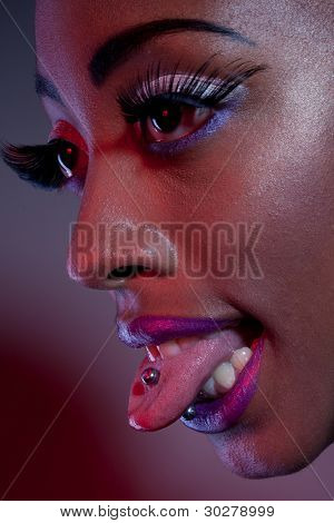 Närbild profil av en afrikansk kvinna med sin tunga ut visar henne tungan piercing