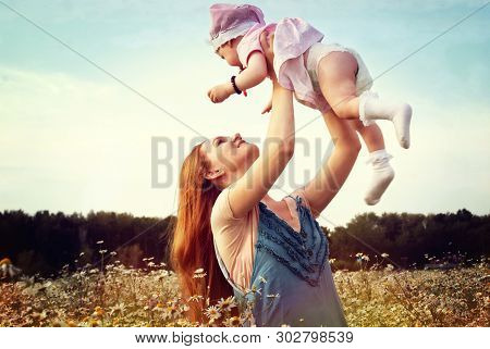 Young Mother With Her Daughter In Nature