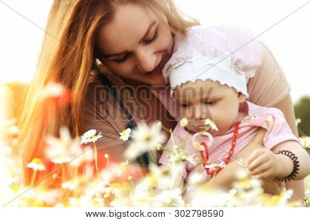 Young Mother Holds Her Daughter In Her Arms