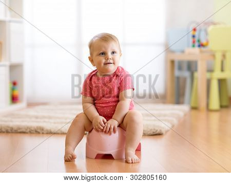 Little Smiling Baby Girl Sitting On A Pot. Isolated On White Background.