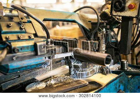 Automatic Band Saw Machine Cutting Raw Steel Rods. The Band Saw Machine Cutting Raw Metals Rods The 
