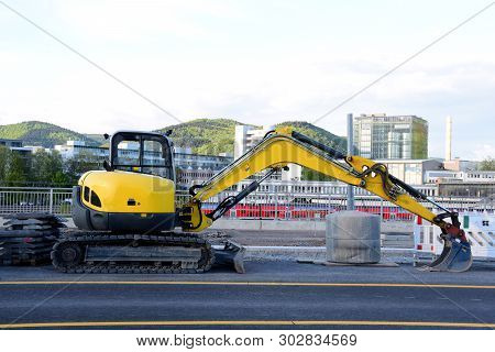Heidelberg. May 2019. The Car On A Caterpillar With A Bucket For Road Works Of Yellow Color Costs On