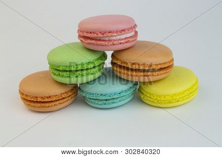Colorful Macaroni Cakes On White Background. Sweets Many Colors Pink, Orange, Yellow, Blue. Baking, 