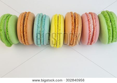 Multicolored Macaroni Biscuits On A White Background Close-up. Green Blue Red Yellow Macaroni Laid O