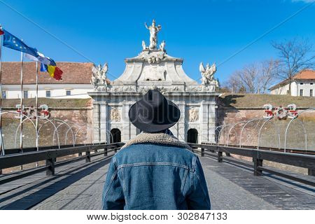 A Tourist Young Man With A Hat Admiring A Fortress Gate Entrance. A Man Admiring The 3Rd Gate Of The