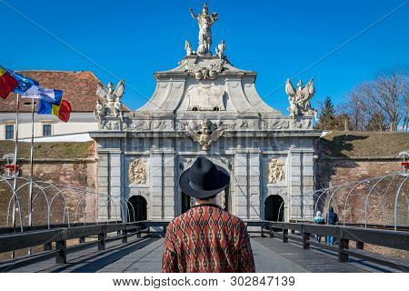 A Tourist Young Man With A Hat Admiring A Fortress Gate Entrance. A Man Admiring The 3Rd Gate Of The