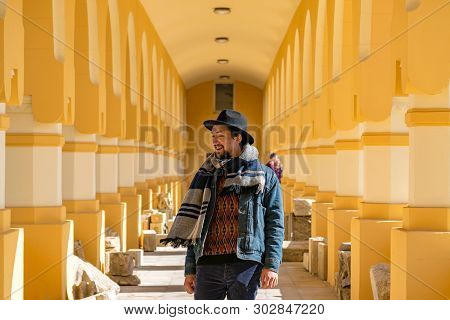 Portrait Of A Stylish Handsome Young Man With A Scarf Outdoors.  A Happy Man Wearing A Scarf, Hat An