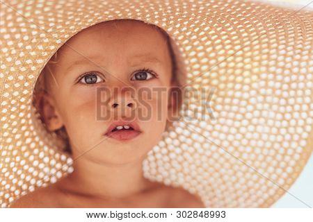 Happy Baby Boy In The Srtaw Hat. Child Injoying Summer Day At The Beach. Outdoor, Close Up.