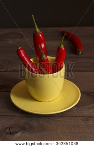 Red Hot Caen Chili Pepper, A Few Fire Peppers, Food Seasoning, Caen Pepper In A Yellow Cup On A Wood