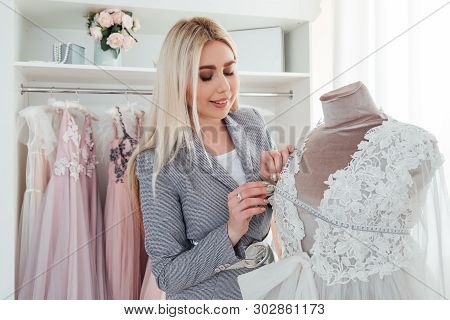 Luxury Showroom. Fashion Advisor Examining Designer Evening Dress From Latest Collection. Trendsette