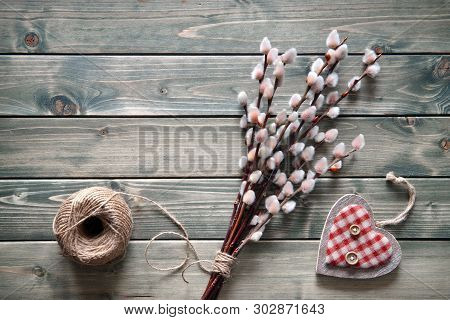 Springtime Background With Bunch Of Pussy-willow Twigs Tightened By Cord And Wooden Heart On Rustic 