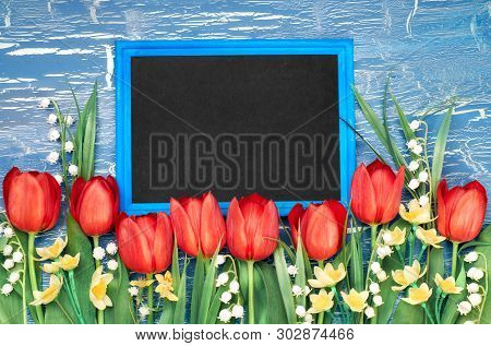Blackboard With Red Tulips And Lily Of The Valley Flowers On Blue Rustic Background. Space For Your 