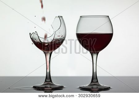 Wine. Red Wine Pouring Into Broken Wine Glass On The Wet Surface. Rose Wine Pour. Close Up Shot. Whi