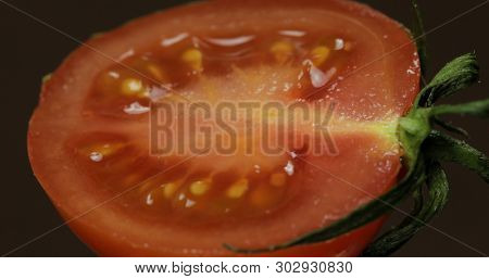 Halves Of Fresh Ripe Cut Tomato On A Dark Background.