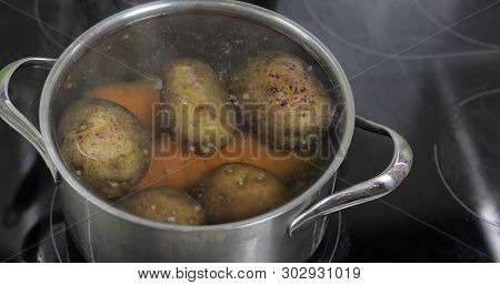 Hot Boiling Pan With Vegetables Potatoes And Carrots. Cooking In A Pan On The Home Kitchen