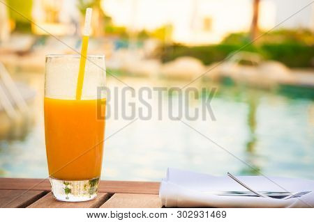 Glass Of Fresh Mango Juice On Table Near Pool