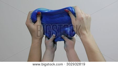 Woman And Child Hands Playing With Oddly Satisfying Blue Slime Sticky Gooey Substance On White Backg
