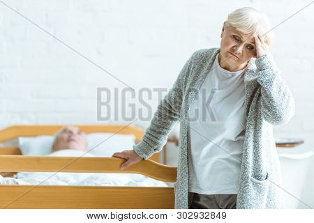 Upset Senior Woman And Man In Coma In Clinic
