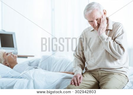 Sad Senior Man And Senior Woman In Coma In Hospital