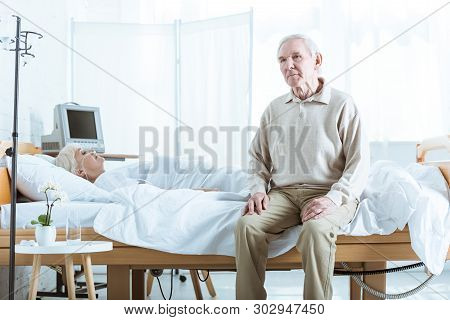 Sad Senior Man And Senior Woman In Coma In Hospital