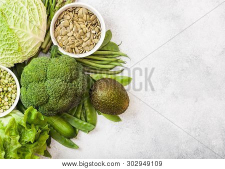 Assorted Green Toned Raw Organic Vegetables On White Stone Background. Avocado, Cabbage, Broccoli, C