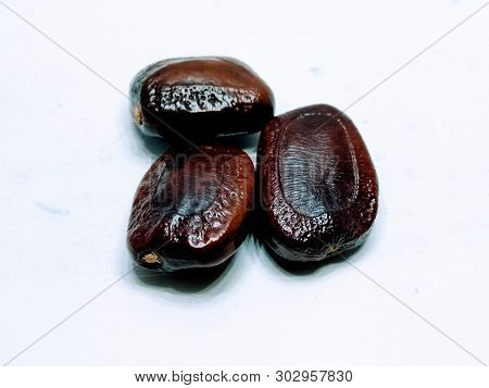 A Picture Of Tamarind Seeds On White Background