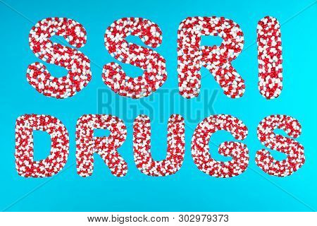 Inscription Ssri Drugs White And Red Pills On A Blue Background Top View. Concept Of Selective Serot