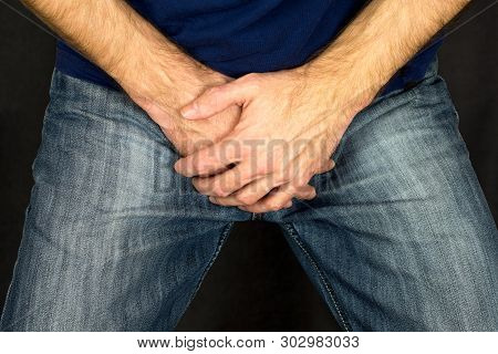 Erectile Dysfunction Concept. Close Up Of A Man With Hands Holding His Crotch Dark Background. Men's