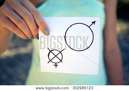 Gender Discrimination Concept, A Piece Of Paper With A Female And A Male Symbol In A Woman's Hand