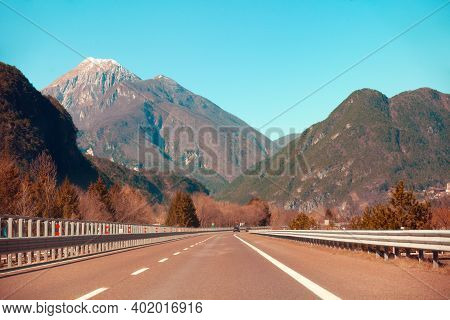 View Of Beautiful Mountain Landscape Through The Windscreen On A Sunny Day. Driving A Car On Mountai