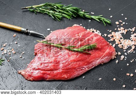 Raw Flat Iron Steak With Rosemary And Pink Salt. Fresh Marble Beef Meat Black Angus. Black Backgroun
