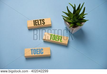 Ielts, Toefl, Toeic Word On Wooden Blocks On Blue Background