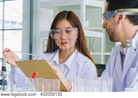 Doctor And Microbiologist With Vacuum Tubes For Samples With Covid 19 Infection Atypical Pneumonia V