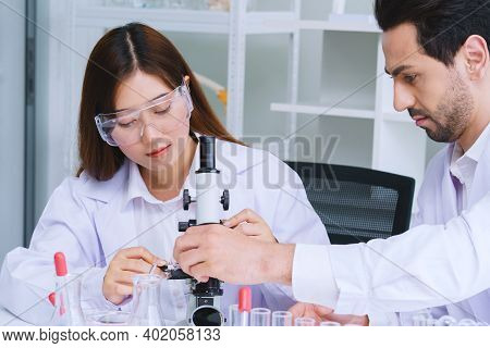 Doctor And Microbiologist With Vacuum Tubes For Samples With Covid 19 Infection Atypical Pneumonia V