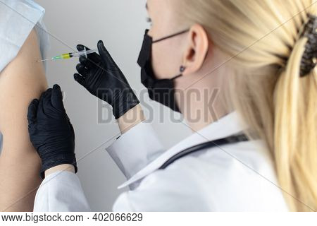 Infectious Disease Doctor Gives The Patient A Medical Vaccination In The Shoulder. Immunization Agai