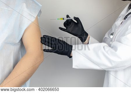 Infectious Disease Doctor Gives The Patient A Medical Vaccination In The Shoulder. Immunization Agai