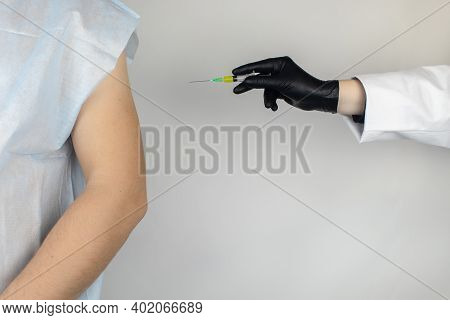 Infectious Disease Doctor Gives The Patient A Medical Vaccination In The Shoulder. Immunization Agai