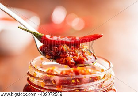 Red hot chili paste and chili pepper on spoon.