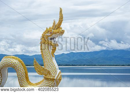 Naga Statue Or Phayanak With A Bright Sky, Clouds, Mountains Background And Freshwater Lake (kwan Ph