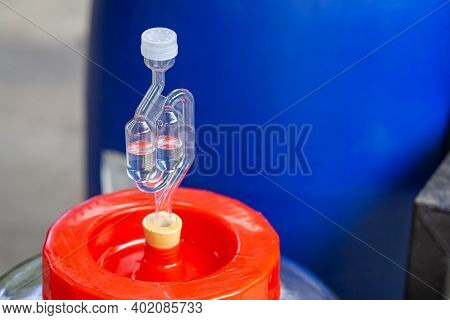 Close-up Of A Bubbling Airlock On Fermentation Container. Rubber Stopper For A Glass Carboy. Process