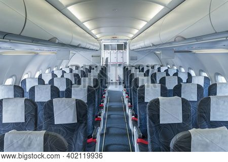 Airplane Cabin And Aisle With Empty Comfortable Seats In Economy Class Inside Of Plane