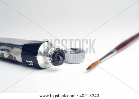 Cepillo y tubo de pintura primer plano aislado sobre fondo blanco