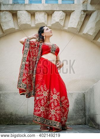 Indian Woman Dance On Streets Of Ancient Architecture City Of India Dressed In Red Sari, Decorated W
