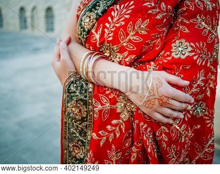Young Beautiful Indian Woman Dancing In Red Sari On Background Walls Ancient Building Outdoors.