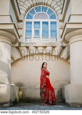 Indian Woman Dance On Streets Of Ancient Architecture City Of India Dressed In Red Sari, Decorated W