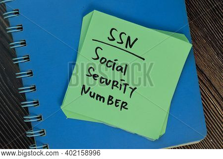 Ssn - Social Security Number Write On Sticky Notes Isolated On Wooden Table.