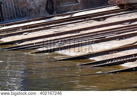 Part Of A Boat Ramp Made Of Wood And Metal On The Water. Dock Of A Shipyard For Small Boats In Need 