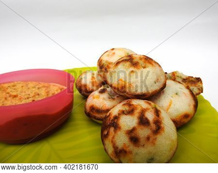 Paddu Or Kuzhi Paniyaram And Coconut Chutney In A Green Plate Isolated On White Background. Indian D