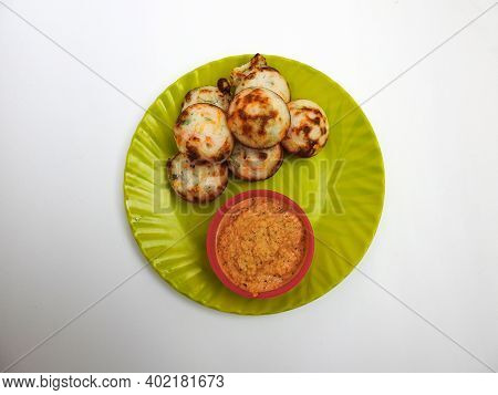 Paddu Or Kuzhi Paniyaram And Coconut Chutney In A Green Plate Isolated On White Background. Indian D