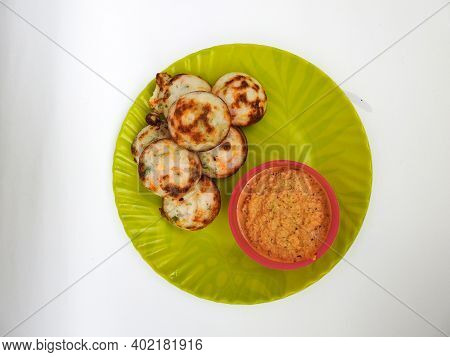 Paddu Or Kuzhi Paniyaram And Coconut Chutney In A Green Plate Isolated On White Background. Indian D